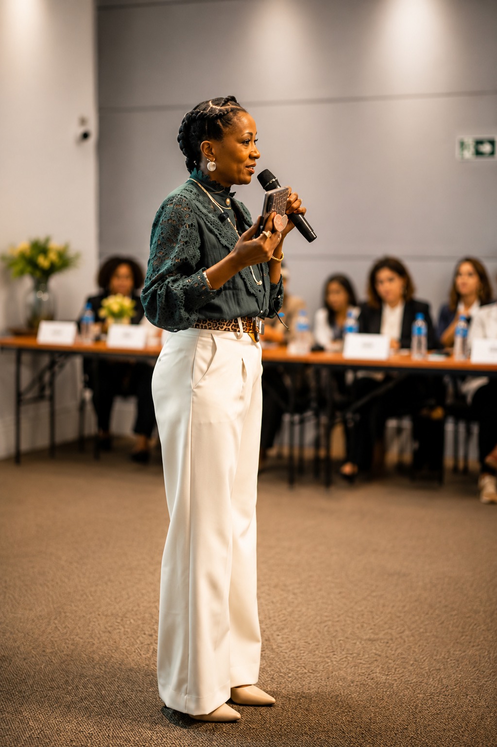 Maura Machado falando ao microfone durante uma palestra